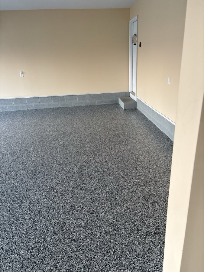 Finished garage floor in a flake blend, edges cut clean to the wall